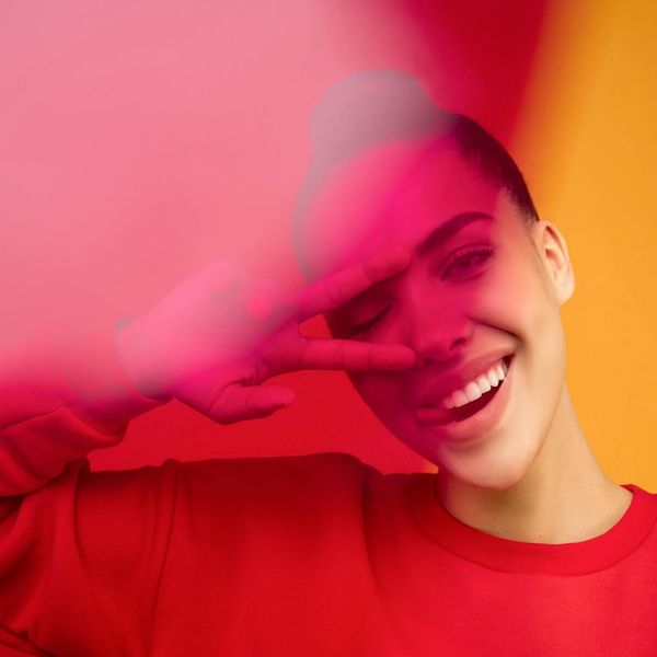 Person meditating peacefully with a vibrant, energetic background.